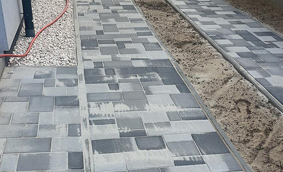 Acera de adoquín bicolor gris durante el rejuntado