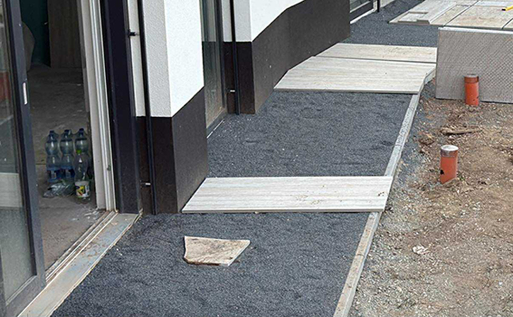 Bordillo y base de gravilla junto al edificio